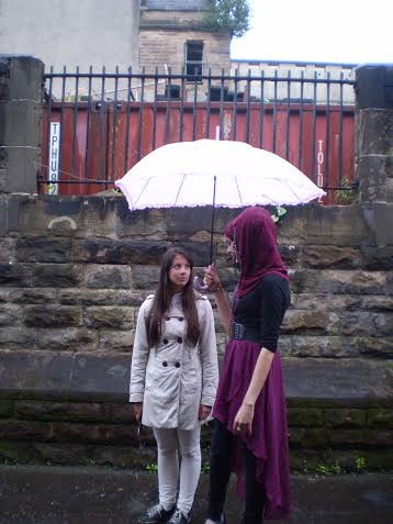 Naziyah Mahmood (Nour-el-ain) and Linn Mattisson (Lee Yoo Min) chatting on set in the rain.